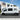 White van in front of Van Mart building with 'Custom Van Conversions' sign.